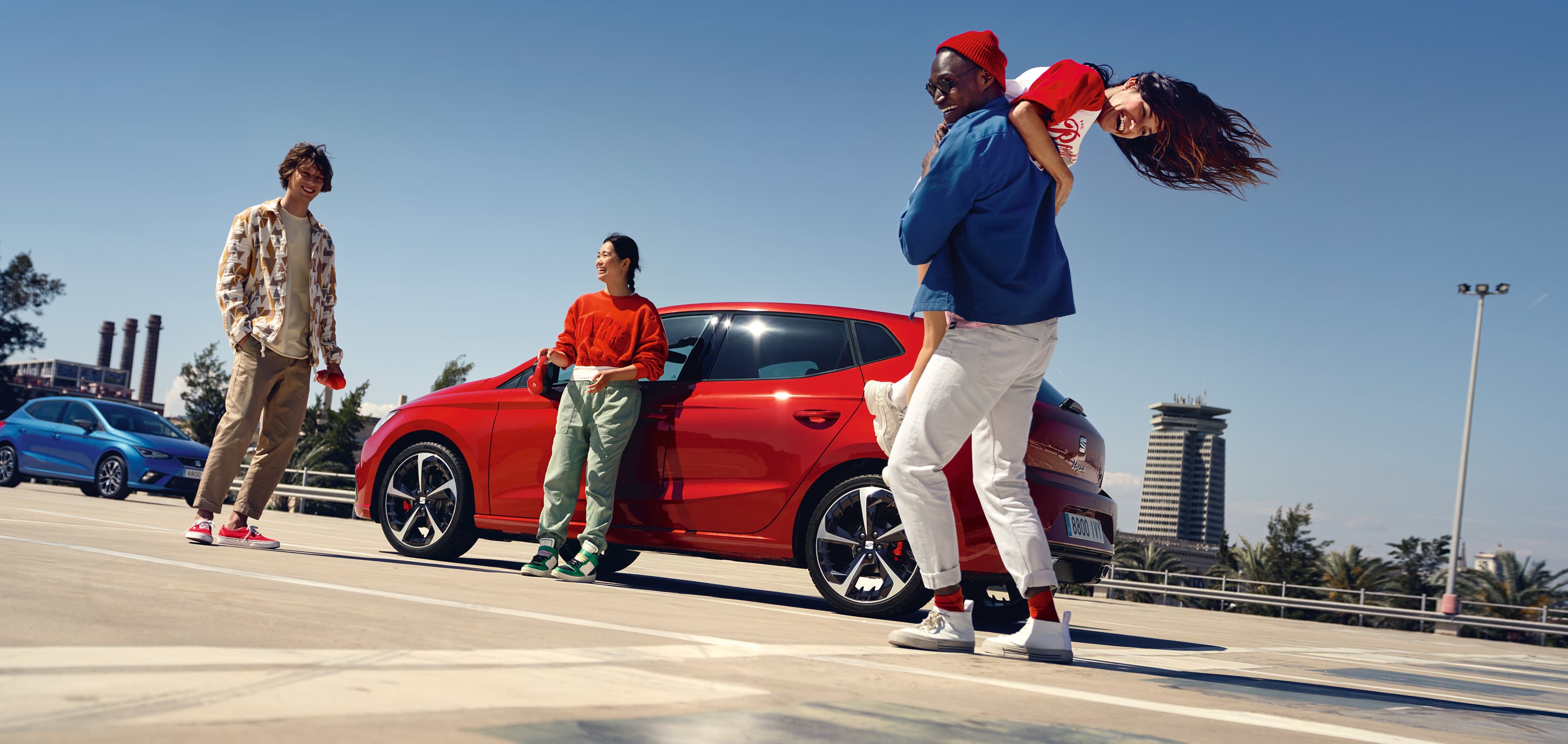 Woman leaning on SEAT Ibiza desire red colour watching her friends