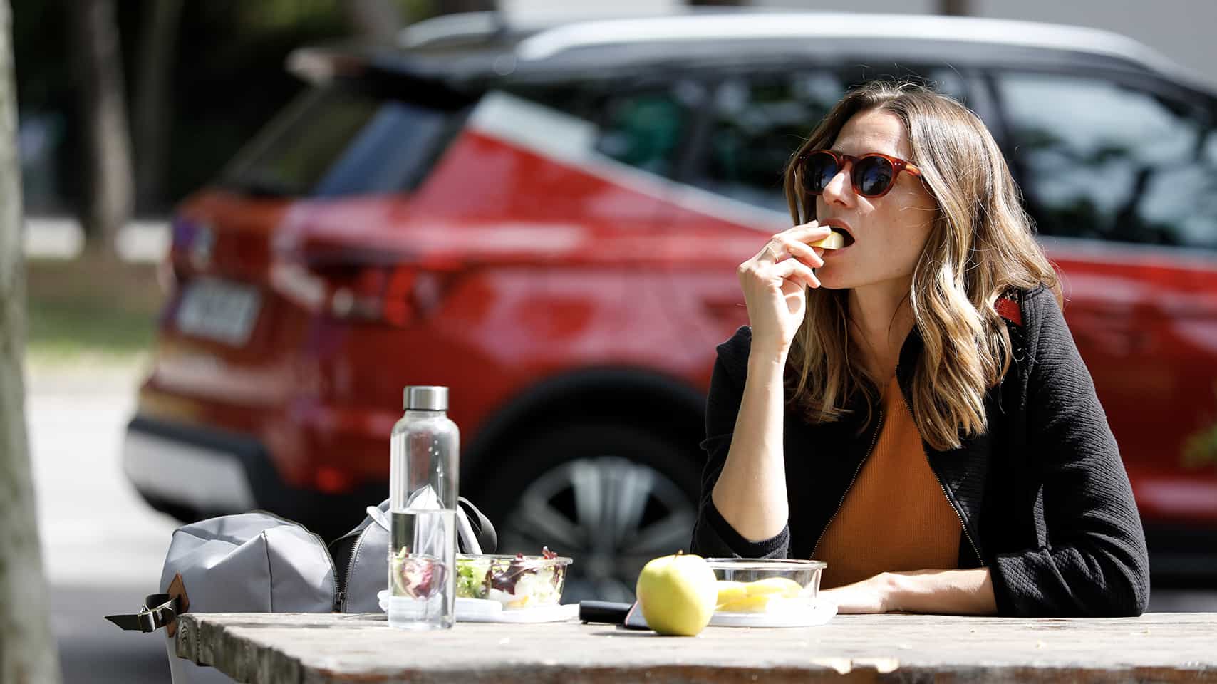 Woman eating  SEAT Arona behind