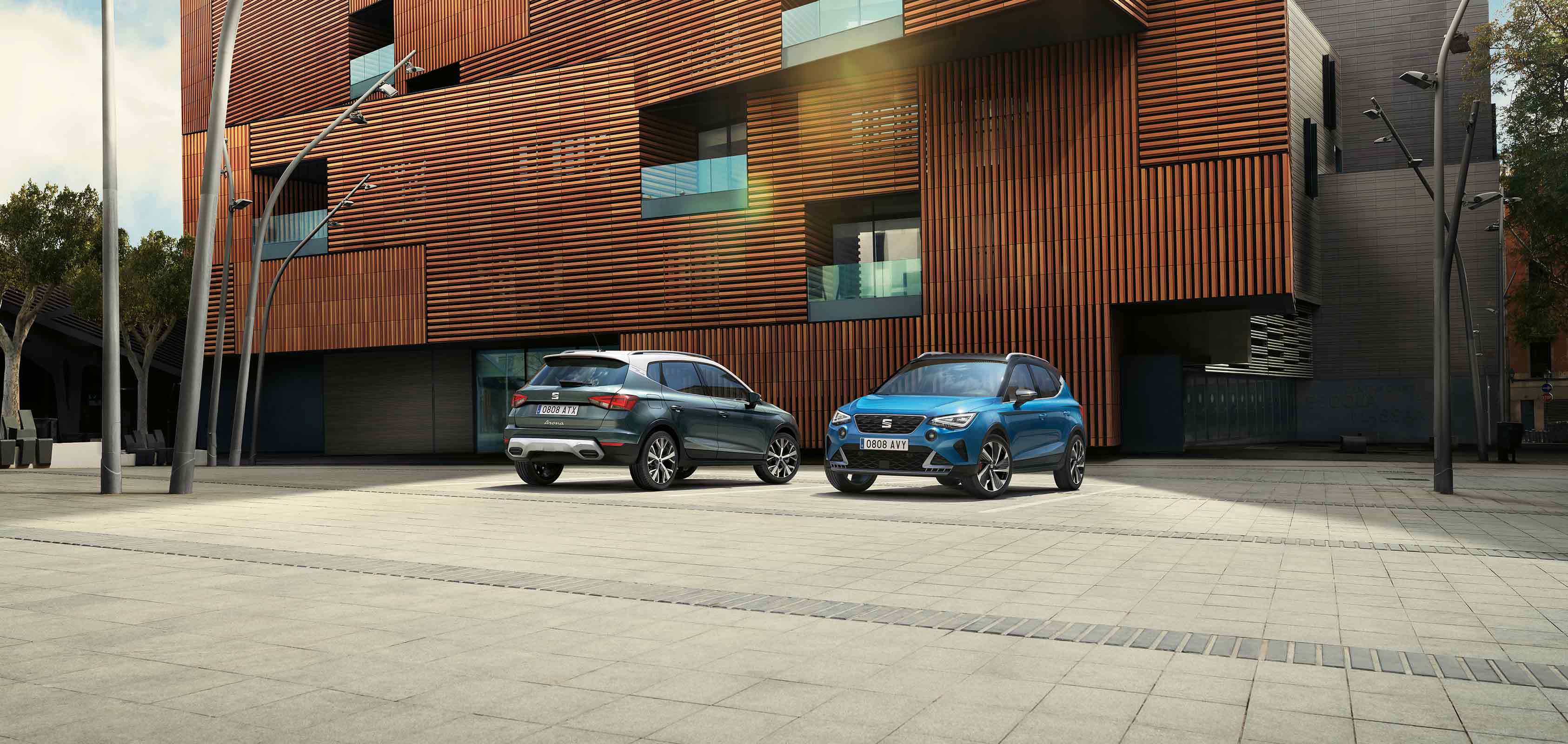 Two SEAT Arona parked, one dark camouflage colour and another Sapphire Blue colour