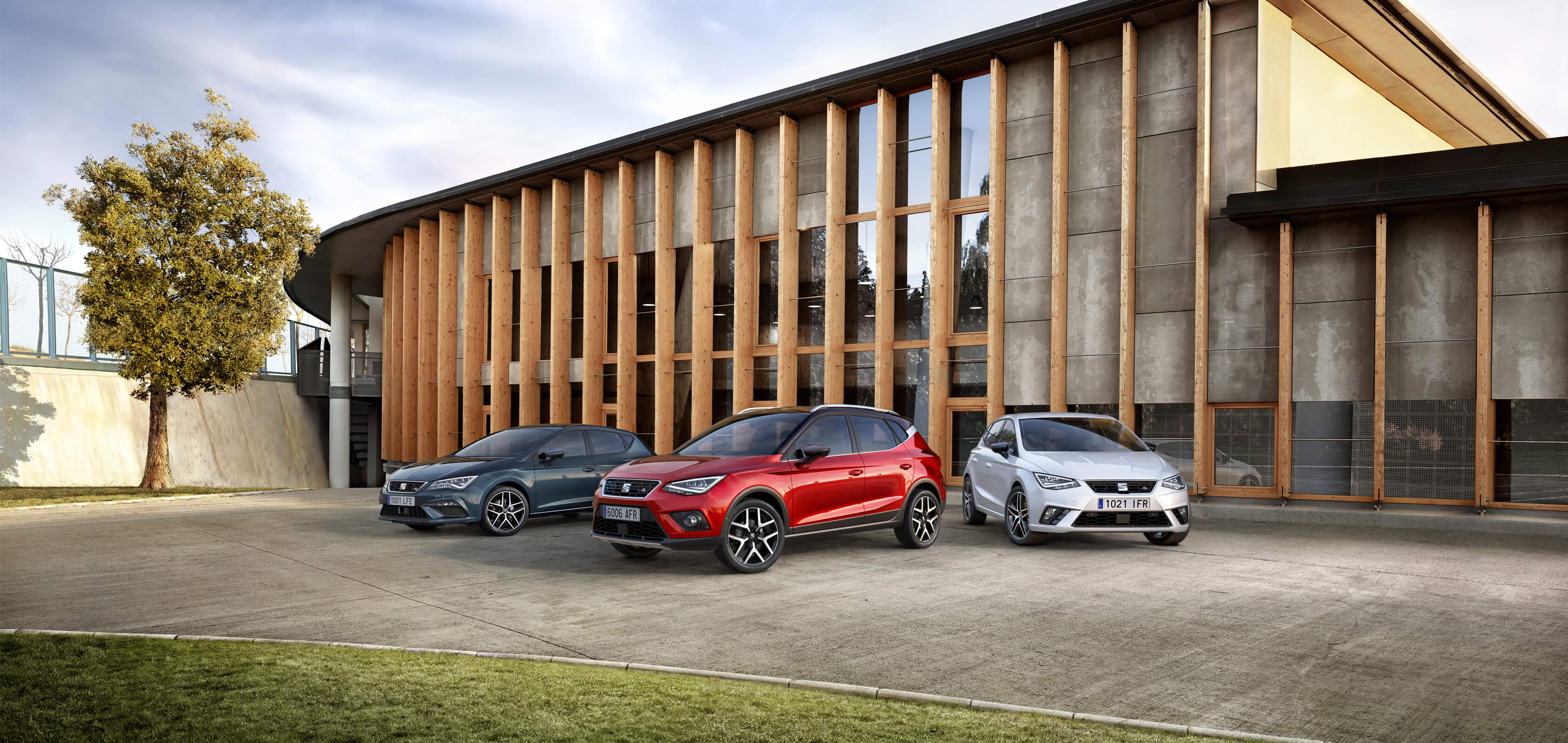 Cars parked in front of a building with wooden panels – SEAT For Business fleet services.