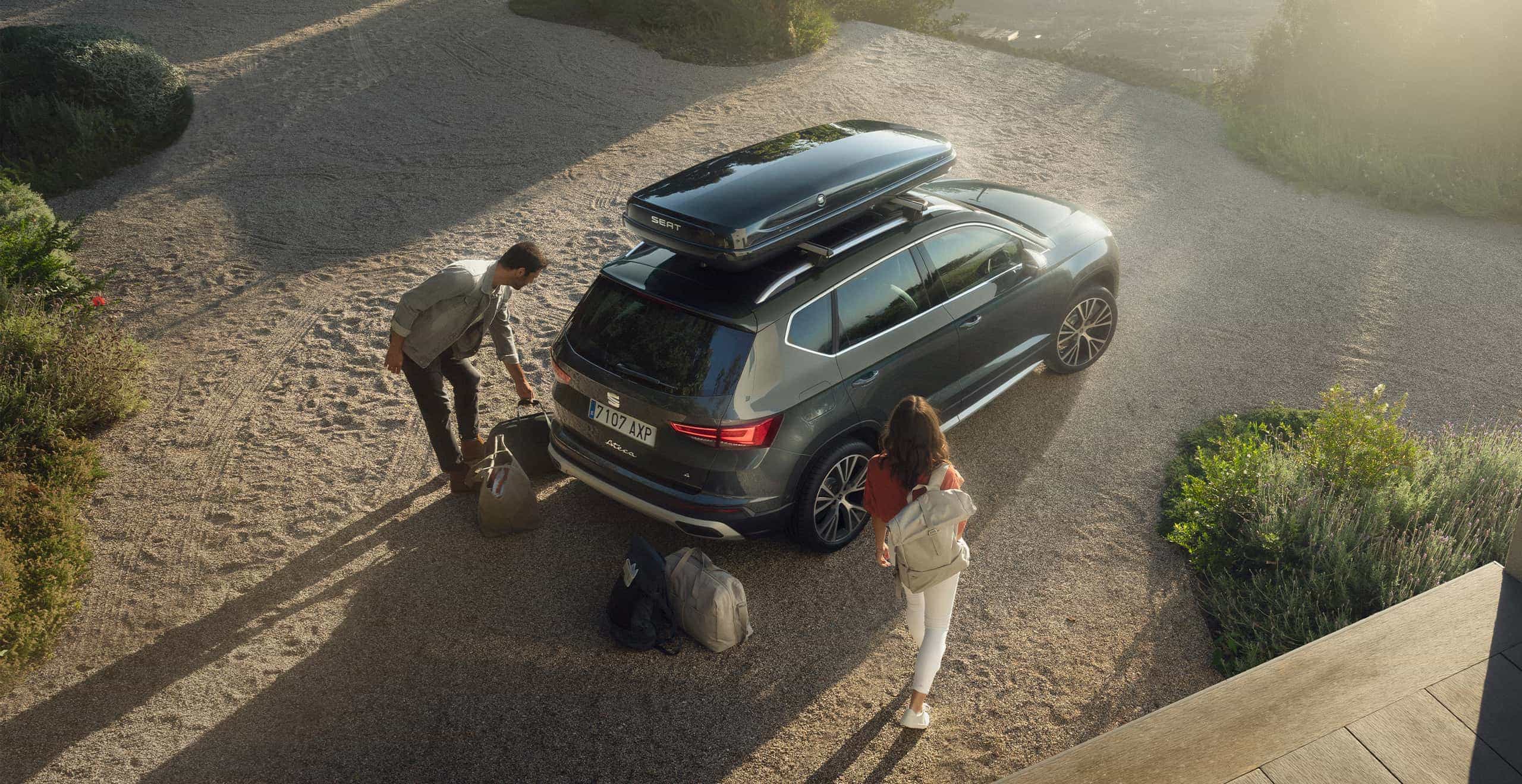 SEAT new car services and maintenance – man placing a bicycle on the bike rack at the back of a SEAT Arona crossover