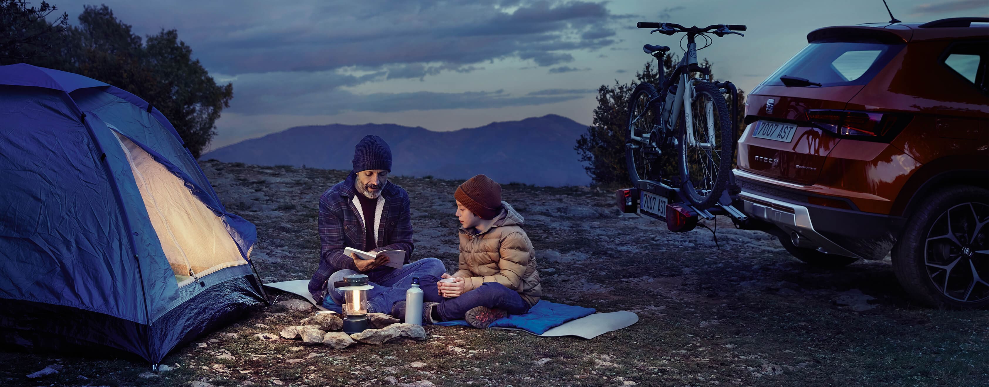 SEAT new car services and maintenance – SEAT Arona crossover SUV parked overlooking a valey with man leaning on the car